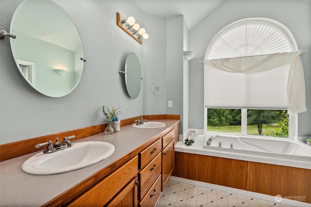 bathroom featuring vanity, a bathtub, and vaulted ceiling