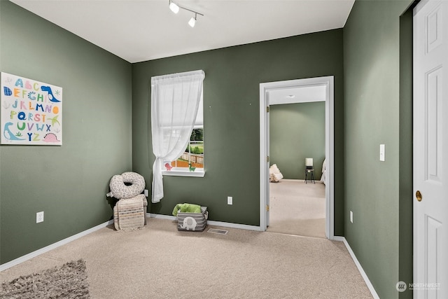 interior space with carpet floors and track lighting