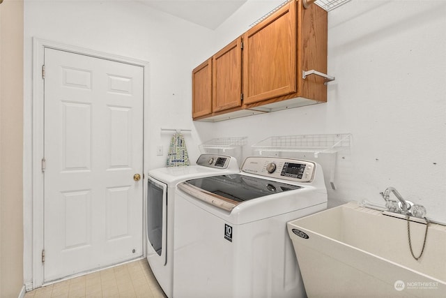 laundry area featuring cabinets, washing machine and clothes dryer, and sink