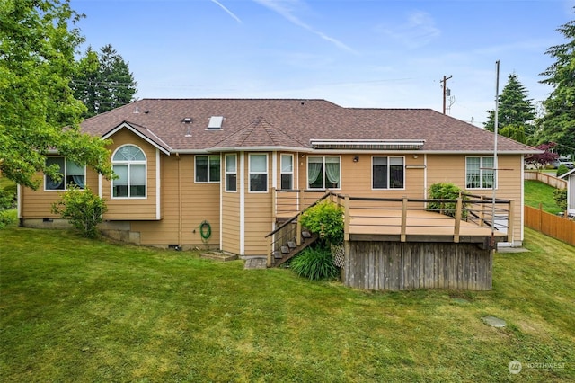 rear view of house with a wooden deck and a yard