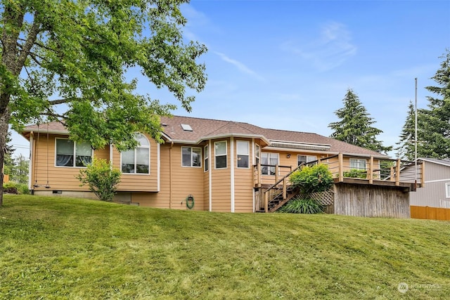 rear view of house with a lawn and a wooden deck