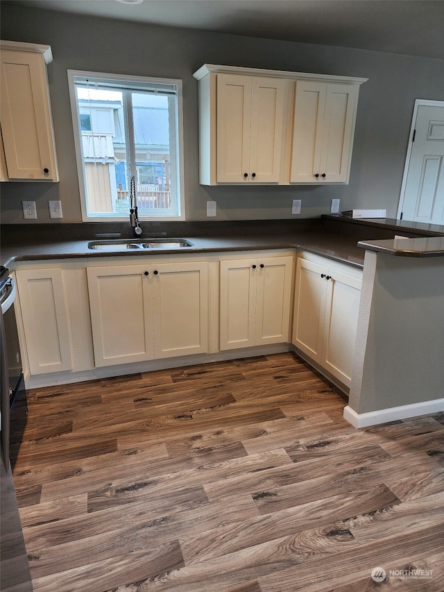 kitchen featuring dark hardwood / wood-style flooring, sink, and white cabinets