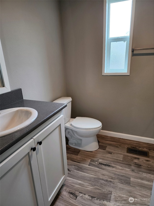 bathroom featuring vanity, hardwood / wood-style flooring, and toilet