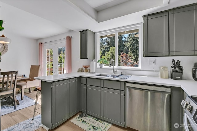 kitchen featuring gray cabinets, sink, stainless steel dishwasher, and light hardwood / wood-style flooring