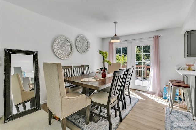 dining space with light wood-type flooring and french doors