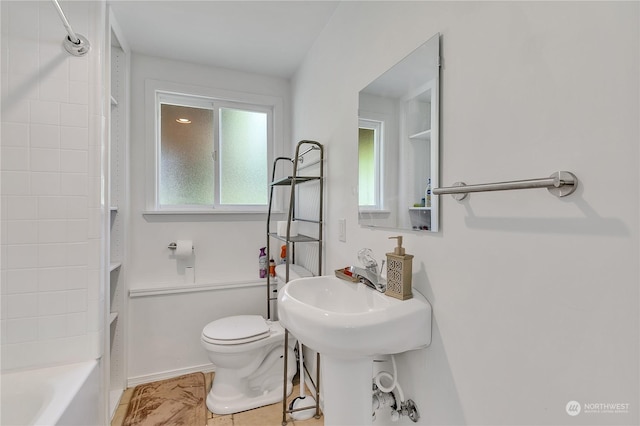 bathroom featuring tile patterned floors, tub / shower combination, and toilet