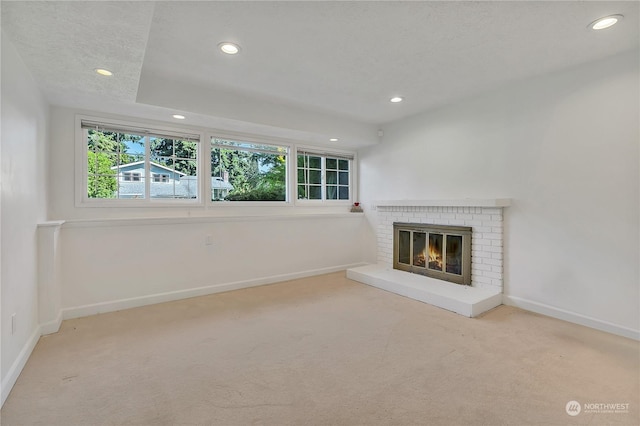 unfurnished living room with light carpet and a brick fireplace