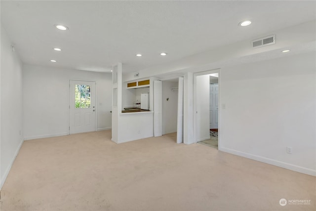 unfurnished living room featuring light colored carpet