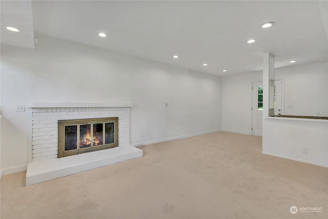 unfurnished living room featuring a fireplace and light colored carpet