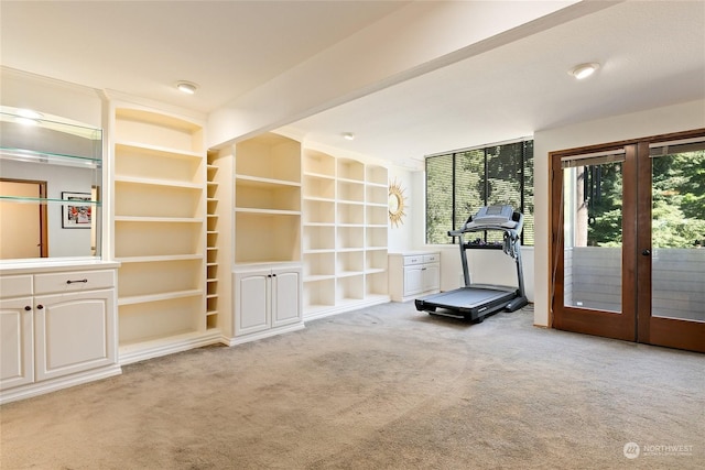 workout room with light colored carpet, french doors, and built in shelves