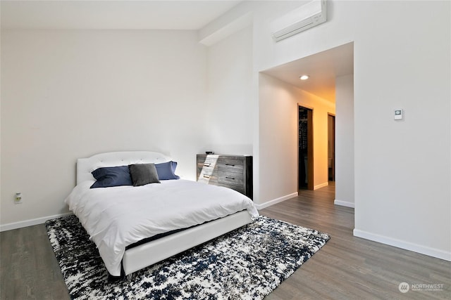 bedroom with dark wood-type flooring, a wall mounted AC, and vaulted ceiling