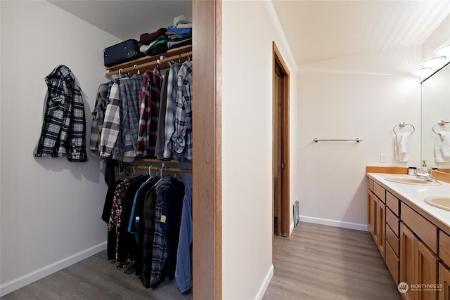 interior space featuring sink, lofted ceiling, and light wood-type flooring