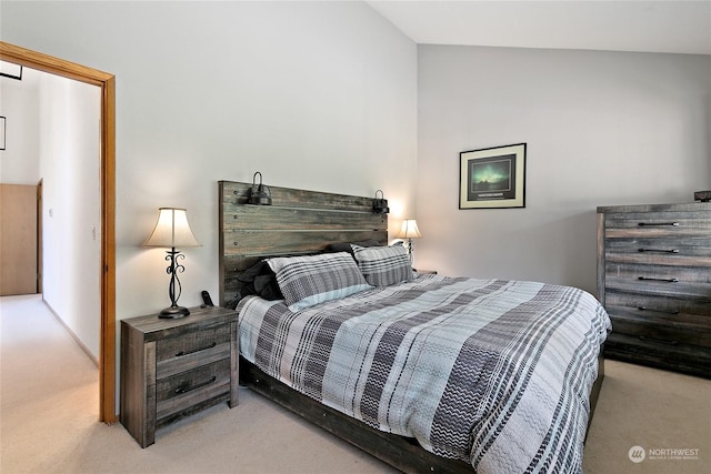 bedroom featuring light colored carpet and vaulted ceiling