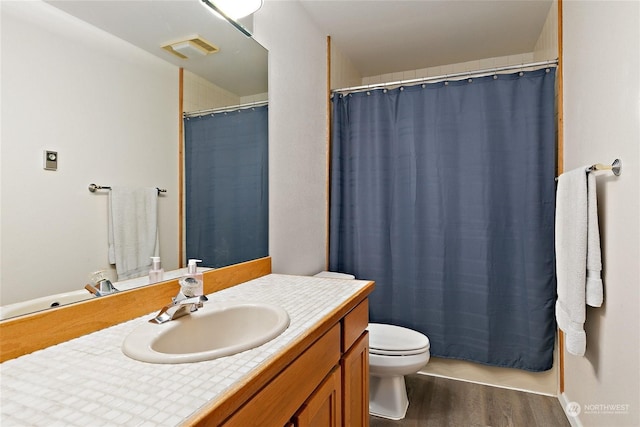 bathroom with hardwood / wood-style floors, toilet, and vanity