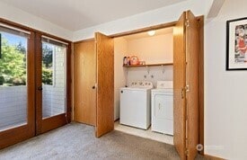 laundry area featuring french doors, carpet flooring, and washer and dryer