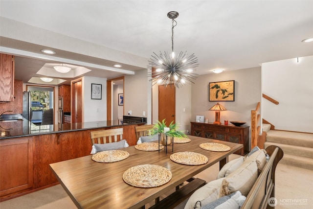 dining area featuring an inviting chandelier, sink, and light carpet