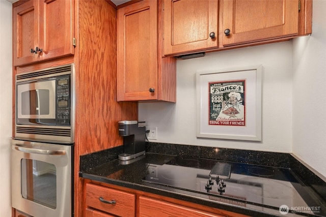 kitchen featuring appliances with stainless steel finishes and dark stone countertops