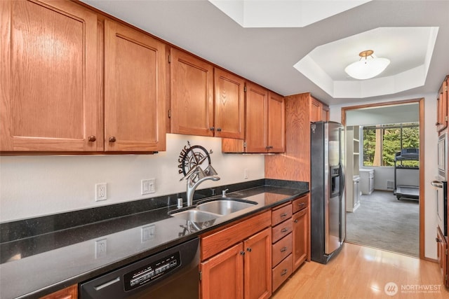 kitchen with dishwasher, sink, light hardwood / wood-style floors, stainless steel fridge with ice dispenser, and a raised ceiling