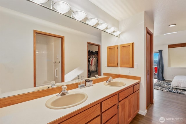 bathroom featuring vanity, wood-type flooring, and walk in shower