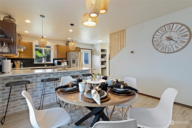 dining room featuring sink and light hardwood / wood-style flooring