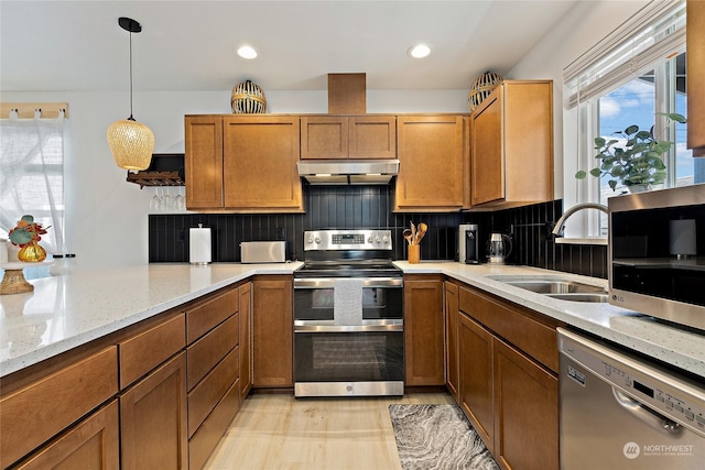 kitchen featuring sink, appliances with stainless steel finishes, hanging light fixtures, light stone counters, and tasteful backsplash