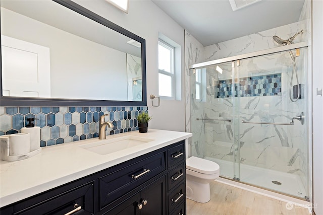 bathroom featuring backsplash, hardwood / wood-style flooring, vanity, an enclosed shower, and toilet