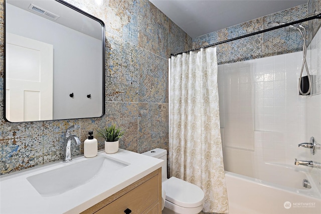 full bathroom featuring vanity, toilet, shower / tub combo, and tile walls