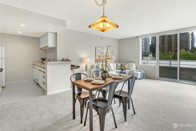 dining room with light carpet and sink