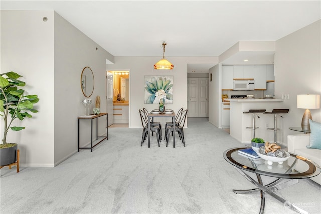 dining space featuring light carpet