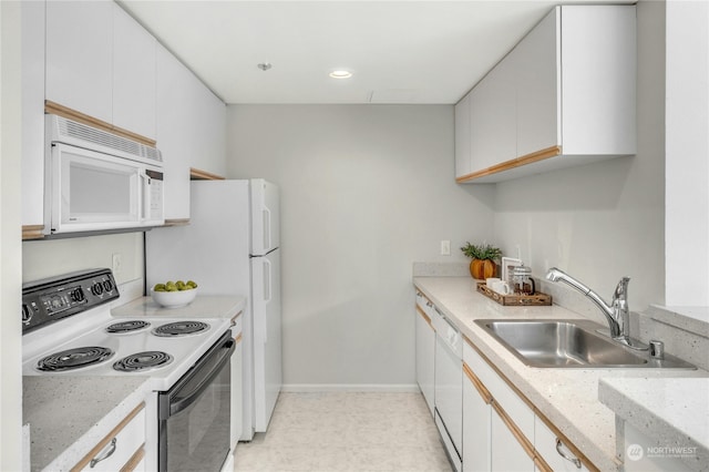 kitchen with white appliances, white cabinetry, and sink