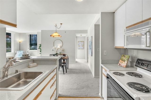 kitchen with white cabinets, pendant lighting, white appliances, and light carpet