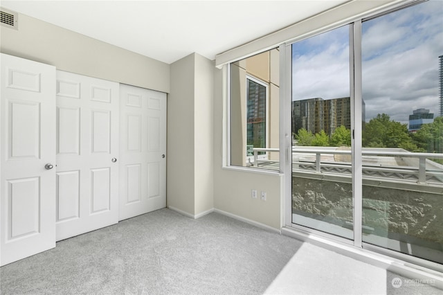 unfurnished bedroom featuring a closet and light colored carpet