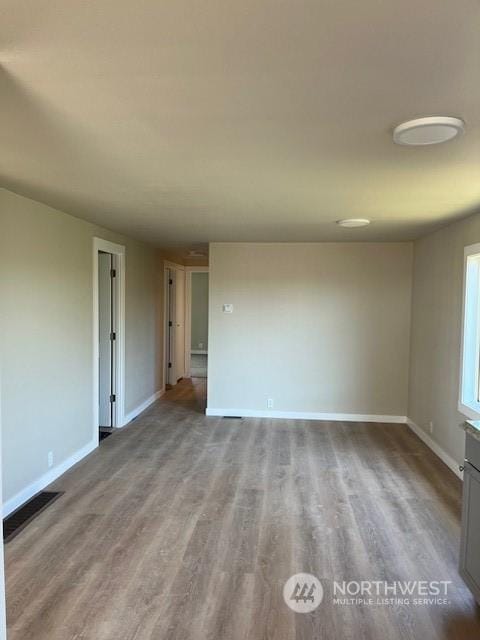 unfurnished room featuring wood finished floors and baseboards