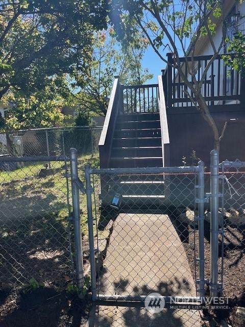 view of home's exterior featuring stairs, fence, and a gate