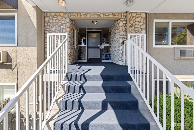 doorway to property featuring stone siding and stucco siding