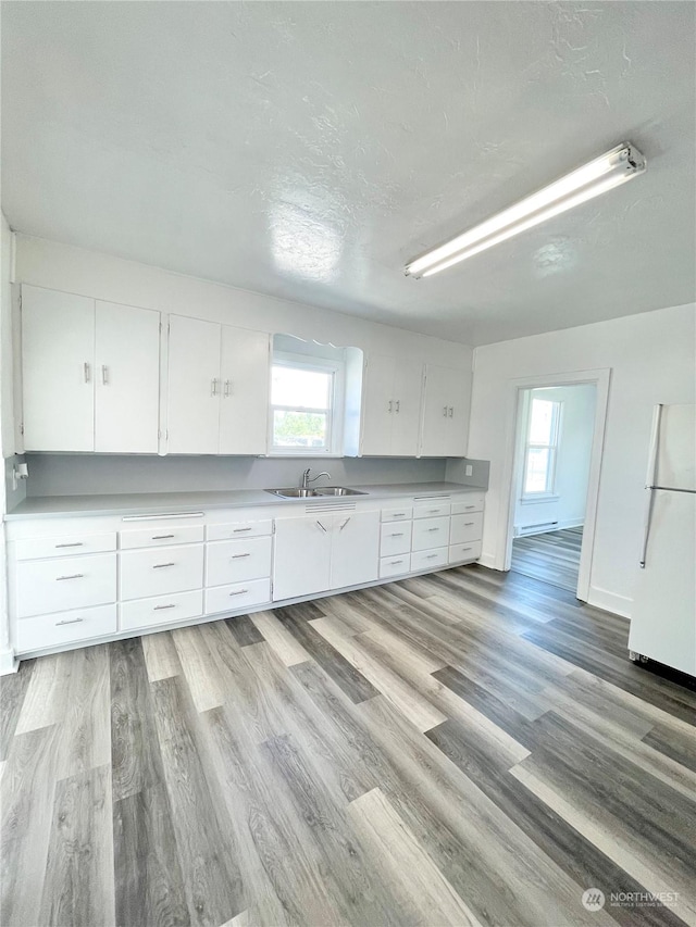 1579 2nd Ave N, Okanogan, WA 98840 - kitchen featuring freestanding refrigerator, a sink, healthy amount of natural light, white cabinetry, and a textured ceiling