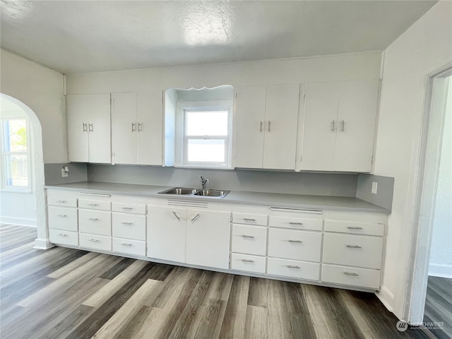 kitchen with sink, white cabinets, and wood-type flooring