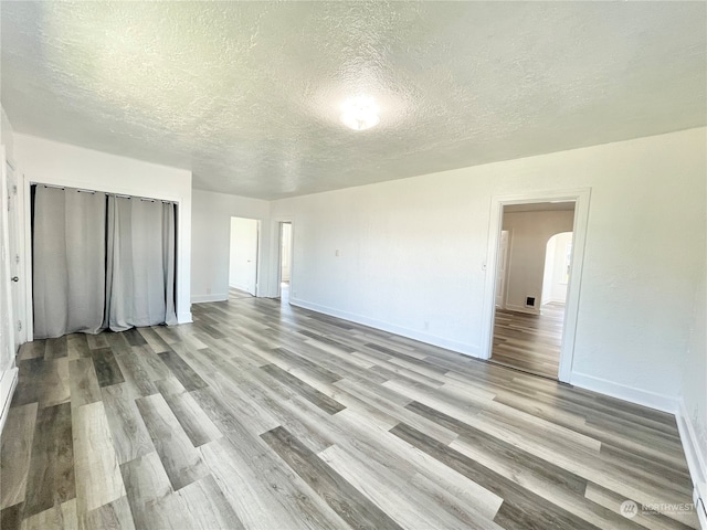 unfurnished bedroom featuring hardwood / wood-style floors and a textured ceiling