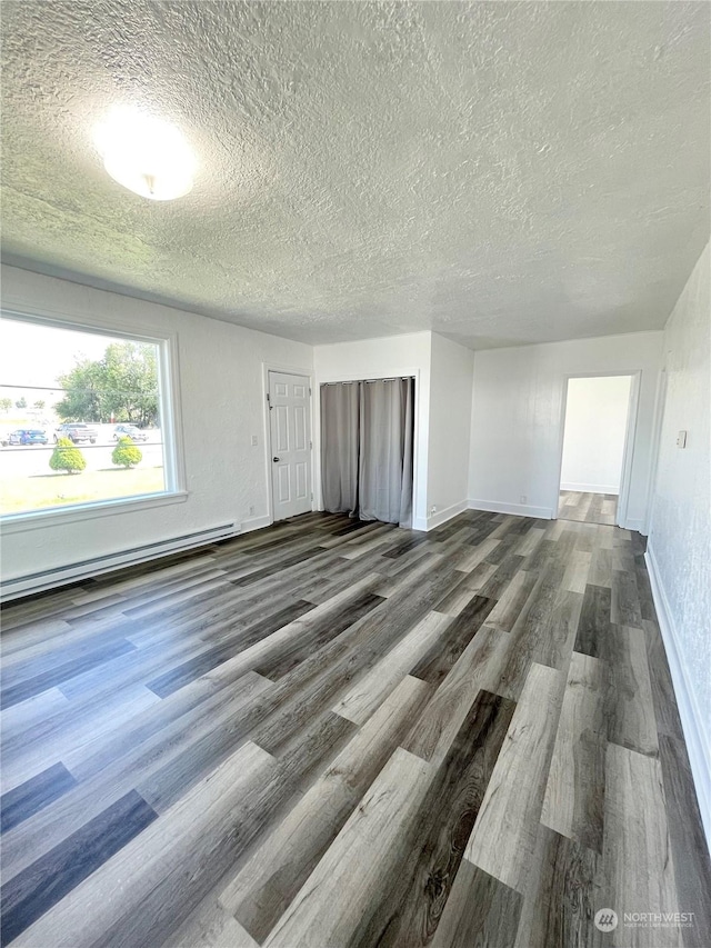 1579 2nd Ave N, Okanogan, WA 98840 - empty room featuring a textured ceiling, a baseboard radiator, dark wood-style flooring, and baseboards