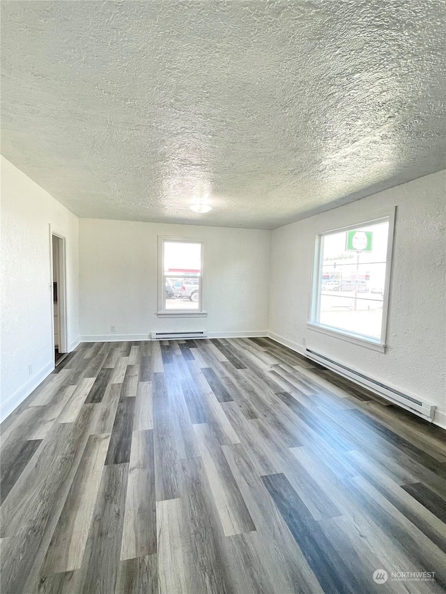 1579 2nd Ave N, Okanogan, WA 98840 - unfurnished living room with baseboard heating, wood finished floors, a textured ceiling, and baseboards