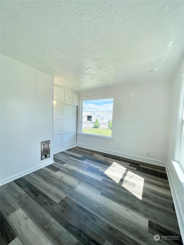 1579 2nd Ave N, Okanogan, WA 98840 - unfurnished room featuring dark wood finished floors, a textured ceiling, heating unit, and baseboards