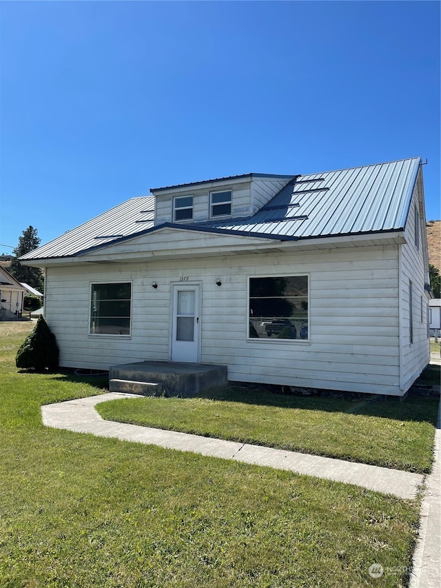 rear view of house featuring a yard