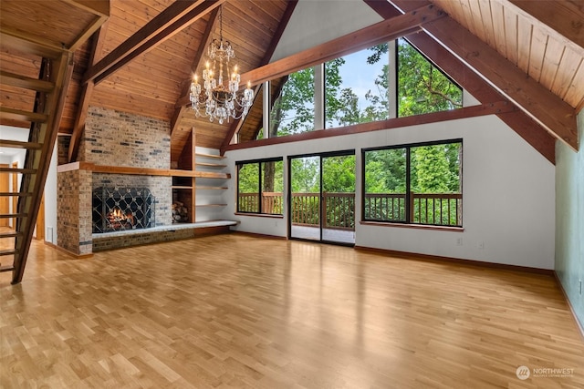 unfurnished living room with a brick fireplace, a notable chandelier, wooden ceiling, and light hardwood / wood-style floors