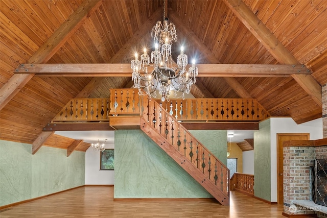 unfurnished living room featuring a chandelier, a fireplace, beamed ceiling, and wooden ceiling