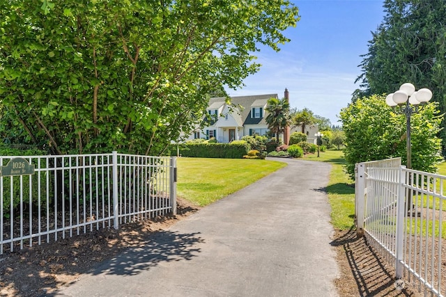 view of gate with a lawn