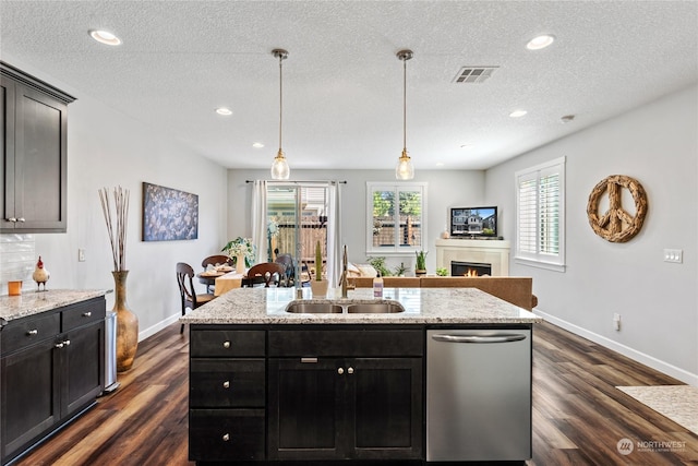 kitchen featuring hanging light fixtures, dishwasher, sink, and a textured ceiling