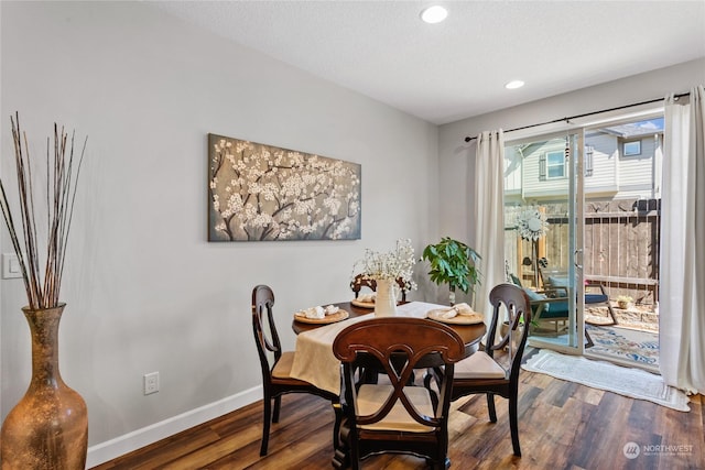 dining space with dark wood-type flooring and a textured ceiling