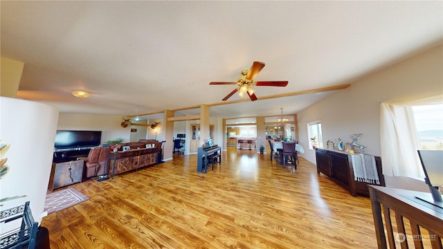 living room featuring ceiling fan with notable chandelier, a healthy amount of sunlight, and wood-type flooring