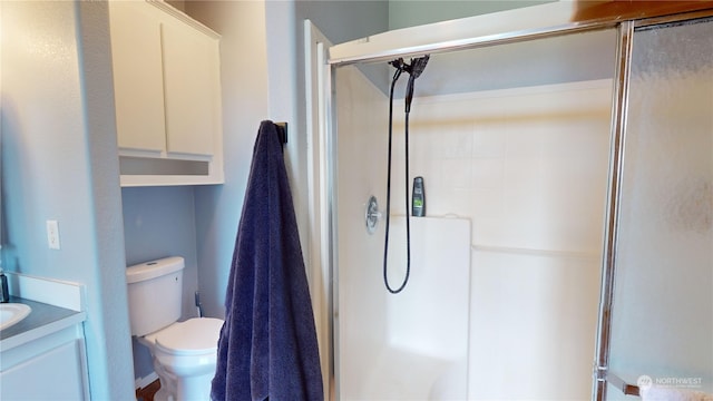 bathroom featuring vanity, toilet, and a shower with door