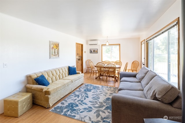 living room with wood-type flooring and a wall mounted air conditioner